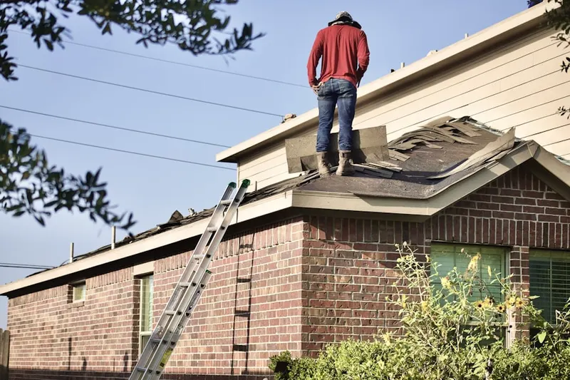Professional roofer working on a residential roof in Jamaica Central - South Sumner
